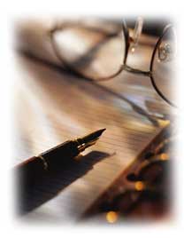 Photo of eye glasses and a fountain pen lying on a executive notepad