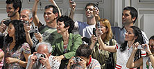 A large group of people taking pictures with their digital cameras and cel phones.