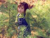 Picture of little girl among pines.