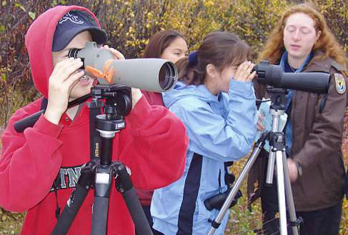 Students and a FWS employee viewing ducks through a spotting scope.  Photo Credit: USFWS