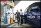 President George W. Bush talks to the media as he stands with Rick Scott, Operations and Safety Coordinator, Shell Hydrogen, L.L.C., Wednesday, May 25, 2005, at a Washington D.C. Shell Station, the first integrated gasoline/hydrogen station in North America.  White House photo by Paul Morse