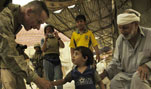 Marine Gen. Peter Pace, chairman of the Joint Chiefs of Staff, says hello to a 2-year old Iraqi child and the child's grandfather while visiting Ramadi, Iraq, July 17, 2007.