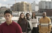 Four people standing on top of a building