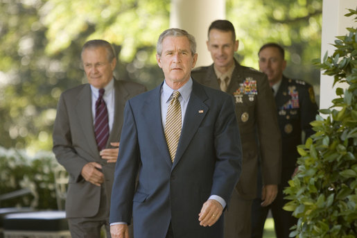 President George W. Bush walks to the Rose Garden Wednesday, Oct. 5, 2005, followed by Secretary of Defense Donald Rumsfeld, General Peter Pace, Chairman of the Joint Chiefs of Staff, and Gen. David Petraeus, former Commander of the Multinational Security and Transition Team in Iraq. White House photo by Paul Morse