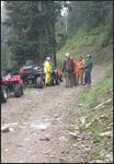 [photo]ATV riders on a forest road.