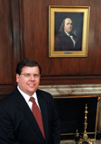 Portrait of Public Printer Robert C. Tapella with picture of Ben Franklin in the background