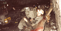 Miner taking a break on an old car seat.