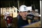 President George W. Bush dons a hard hat as he joins volunteers at a Habitat for Humanity building site Tuesday, Oct. 11, 2005, in Covington, La. White House photo by Eric Draper