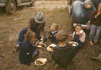 Homesteader and his children eating barbeque at the New Mexico Fair