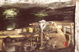 Miner cutting coal at the face of the mine.