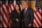 President George W. Bush stands with Volunteer Service Award recipient Marie Arcos of Houston, Texas, in the East Room of the White House, Friday, Oct. 7, 2005, where President Bush honored six recipients of the President's Volunteer Service Awards, as part of the celebration of Hispanic Heritage Month. White House photo by Eric Draper