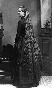 Photo of a woman in a long dress with  long hair down to her knees.