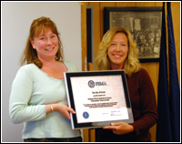 Mayor of Nome, Alaska, Denise Michels (L) receives recognition for her city’s CRS achievements from FEMA Regional Administrator Susan Reinertson. FEMA News Photo, Robert Forgit.