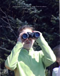 A picture of a small child looking through a pair of  binoculars.  The quote on the image says, Study nature, love nature, stay close to nature.  It will never fail you. – Frank Lloyd Wright.