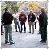 A photograph of several men and women standing outside in a semi-circular pattern.