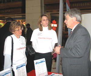 Associate Administrator for Healthcare Systems Joyce Somsak and Poison Control Program Director Lori Roche visit with Dr. Stuart Heard, President, American Association of Poison Control Centers, at the association's exhibit.