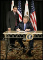 President George W. Bush signs S. 260, The Partners for Fish and Wildlife Act, in Stockton, Calif., Tuesday, Oct. 3, 2006. Pictured with President Bush is Congressman Richard Pombo, R-Ca. The legislation provides assistance to private landowners for voluntary projects to benefit federal trust species by promoting habitat improvement, restoration, enhancement, and establishment; and other public and private entities regarding fish and wildlife habitat restoration on private land. White House photo by Eric Draper