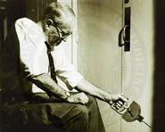 Photo: man pulling on an instrument, possibly to measure arm strength.