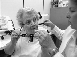Doctor conducting an eye examination on a woman sitting in a chair