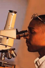 Man looking into microscope.