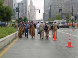 Picture of Commissioned Corps officers heading into Ground Zero as firefighters and other volunteers leave