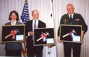 Rose Quicker, VA revenue officer; John Hisle, HRSA's FOH director; and Maj. Gen. Thomas Plewes, Army Reserve chief, display their joint 'Hammer' Awards.