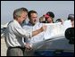 President George W. Bush receives a briefing on hurricane damage from FEMA Director Mike Brown in Punta Gorda, Florida, Sunday, Aug. 15, 2004. White House photo by Eric Draper.