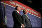 President George W. Bush stands next to Greensburg Schools Superintendent Darin Headrick before making remarks during commencement ceremonies for the Greensburg High School graduating class of 2008. The town of Greensburg, KS was almost entirely destroyed when a tornado tore through the town one year ago today. White House photo by Chris Greenberg