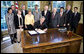 President George W. Bush signs H.R. 493, the Genetic Information Nondiscrimination Act of 2008, Wednesday, May 21, 2008, in the Oval Office. The Genetic Information Nondiscrimination Act would prevent health insurers from canceling, denying, refusing to renew, or changing the terms or premiums of coverage based solely on a genetic predisposition toward a specific disease. The legislation also bars employers from using individuals’ genetic information when making hiring, firing, promotion, and other employment-related decisions. White House photo by Eric Draper