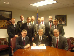 MSHA Acting Assistant Secretary Richard E. Stickler, center, and Brian McCarthy, President and CEO,  of the Portland Cement Association, left, sign agreement to work together to promote a national dialogue on the safety and health of employees working in the cement industry.