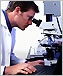 a photo of a scientist using a microscope