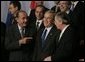 President George W. Bush talks with French President Jacques Chirac, left, and European Union President Jean-Claude Juncker as world leaders take their places for the official NATO group photo in Brussels Tuesday, Feb. 22, 2005. White House photo by Eric Draper