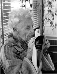 Image of an elderly women reading with a magnifying glass