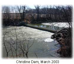 Photo of a dam. There are trees a long the shore.