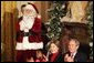 President George W. Bush Laura Bush watch a puppet show and sing Christmas Carols with dozens of school children attending the White House Children's Christmas Program in the East Room, Monday, Dec. 6, 2004. White House photo by Susan Sterner