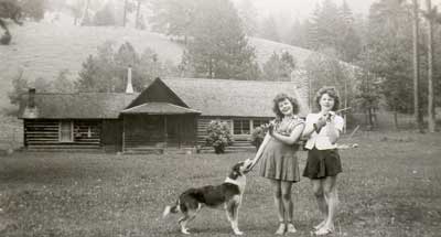 old photo of two girls in front of the cabin