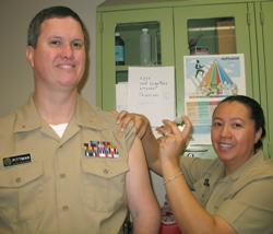 L C D R Karen Williams administers a flu shot to R A D M Robert Pittman, the Commissioned Corps' ranking pharmacist.