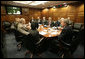 President George W. Bush meets with his National Security team in the White House Situation Room, Friday, March 10, 2006, on the latest developments in Iraq. At the table are Vice President Dick Cheney; Chief of Staff Andy Card; National Security Advisor Stephen Hadley; National Intelligence Director John Negroponte; Central Intelligence Agency Director Porter Goss; U.S. Army General John Abizaid; Chairman Joint Chiefs of Staff U.S. Marine General Peter Pace; Secretary of Defense Donald Rumsfeld and Secretary of State Condoleezza Rice. On screen are U.S. Ambassador to Iraq Zalmay Khalilzad, left, and U.S. Army General George Casey. Seated at far-right are White House Counsel Harriet Miers and Deputy National Security Advisor J. D. Crouch. White House photo by Eric Draper