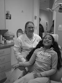 Girl patient in chair with dental staffer