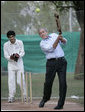 President George W. Bush watches his hit during a cricket clinic with Pakistani youth from the Schola Nova school and the Islamabad College for Boys, Saturday, March 4, 2006, at the Raphel Memorial Gardens on the grounds of the U.S. Embassy in Islamabad, Pakistan. White House photo by Eric Draper