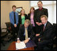 President George W. Bush is joined Tuesday, March 14, 2006 at the Rochester, N.Y., International Airport by family members of Marine Corporal Jason L. Dunham, who was killed in action in the Al Anbar Province of Iraq in April 2004, as President Bush signs a bill designating the post office of Scio, N.Y., to be named the Cpl. Jason L. Dunham Post Office. From left to right are Jason's brother, Kyle James Dunham; sister, Katie; parents, Dan and Deb Dunham, and U.S. Rep. John R. "Randy" Kuhl, Jr., R-N.Y. White House photo by Kimberlee Hewitt