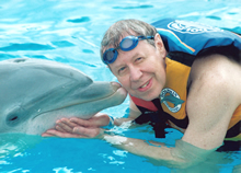 A cute picture - a HRSA employee being kissed by a dolphin.