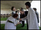 President George W. Bush reaches to shake the hand of Dr. Nirmila Deshpande, as Laura Bush exchanges handshakes with Rajnish Kumar after they were met by the pair Thursday, March 2, 2006 in Rajghat, India for the wreath-laying ceremony at the Mahatma Gandhi Memorial. White House photo by Eric Draper