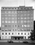 Exterior of an office building with two cars parked in front.