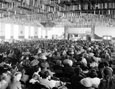 View of a crowded exhibition hall from the back of the hall.