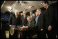 President George W. Bush signs H.R. 6111, the Tax Relief and Health Care Act of 2006, in the Dwight D. Eisenhower Executive Office Building, Dec. 20, 2006. Pictured with the President are, from left: Speaker Dennis Hastert, Sen. Bill Frist, R-Tenn., obscured, Sen. Pete Domenici, R-N.M., obscured, Rep. Bill Thomas, R-Calif., Sen. David Vitter, R-La., Secretary of the Interior, Dirk Kempthorne, obscured, Sen. Mary Landrieu, D-La., Sen. Mike DeWine, R-Ohio and Sen. Rick Santorum, R-Pa. White House photo by Kimberlee Hewitt