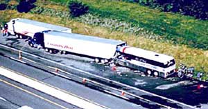 photo of incident scene where a bus left the roadway and entered an “emergency parking area,” striking a parked tractor-trailer and pushing it into a second tractor-trailer