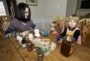 Kristen Kemp, left, has a cup of herbal tea with her three-year-old twin daughters, Annabelle, right, and Estelle at their home in Montclair, N.J., Thursday, Dec. 18, 2008.  Kemp uses home remedies and herbal medicine for her kids' sore throats and colds instead of prescription medications to cut costs.(AP Photo/Mike Derer)