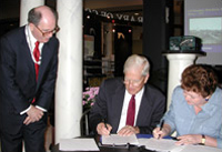 Associate Librarian for Library Services Winston Tabb watches Librarian of Congress James Billington and Open Society Institute-Russia Director Yekaterina Genieva sign an agreement relating to the Meeting of Frontiers program.