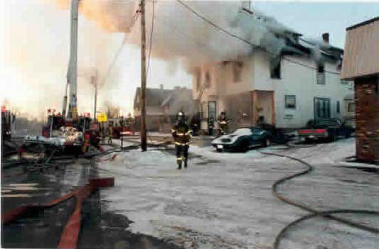 Heavy smoke and fire envelops an occupied residential structure.